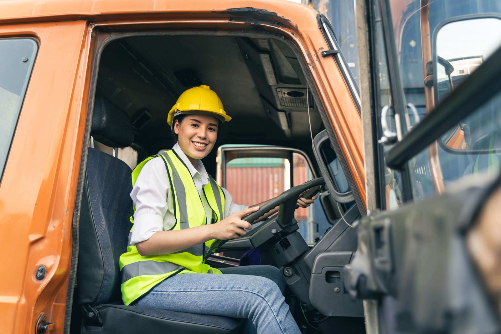 Woman with hard had on in truck smiling