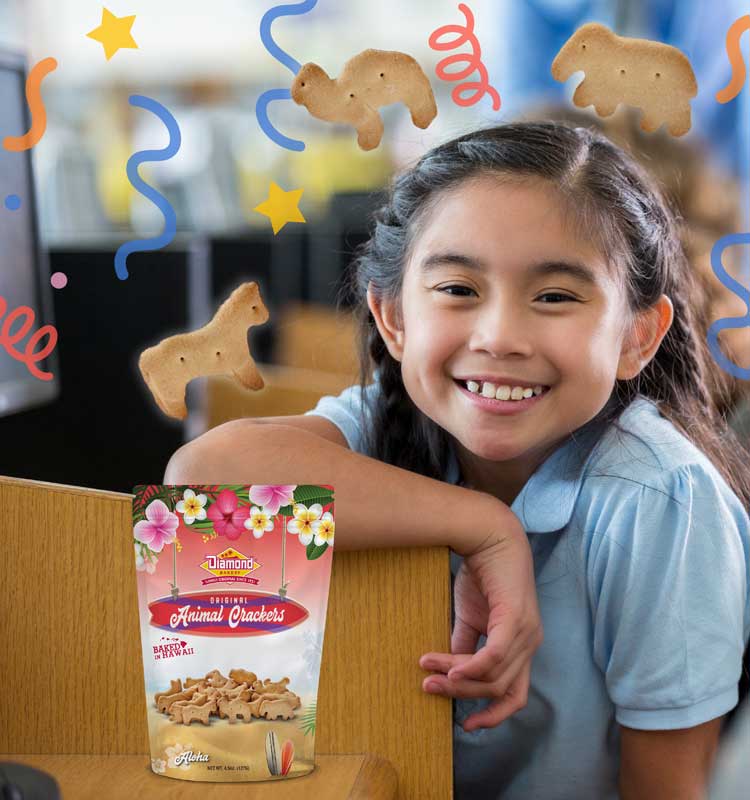 Young girl in classroom with bag of animal crackers, smiling at camera.