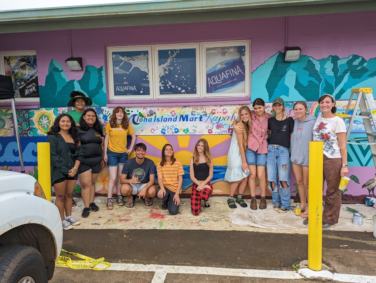 Kapa'a high school students stand in front of a mural