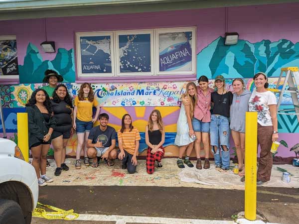 Kapa'a high school students stand in front of a mural